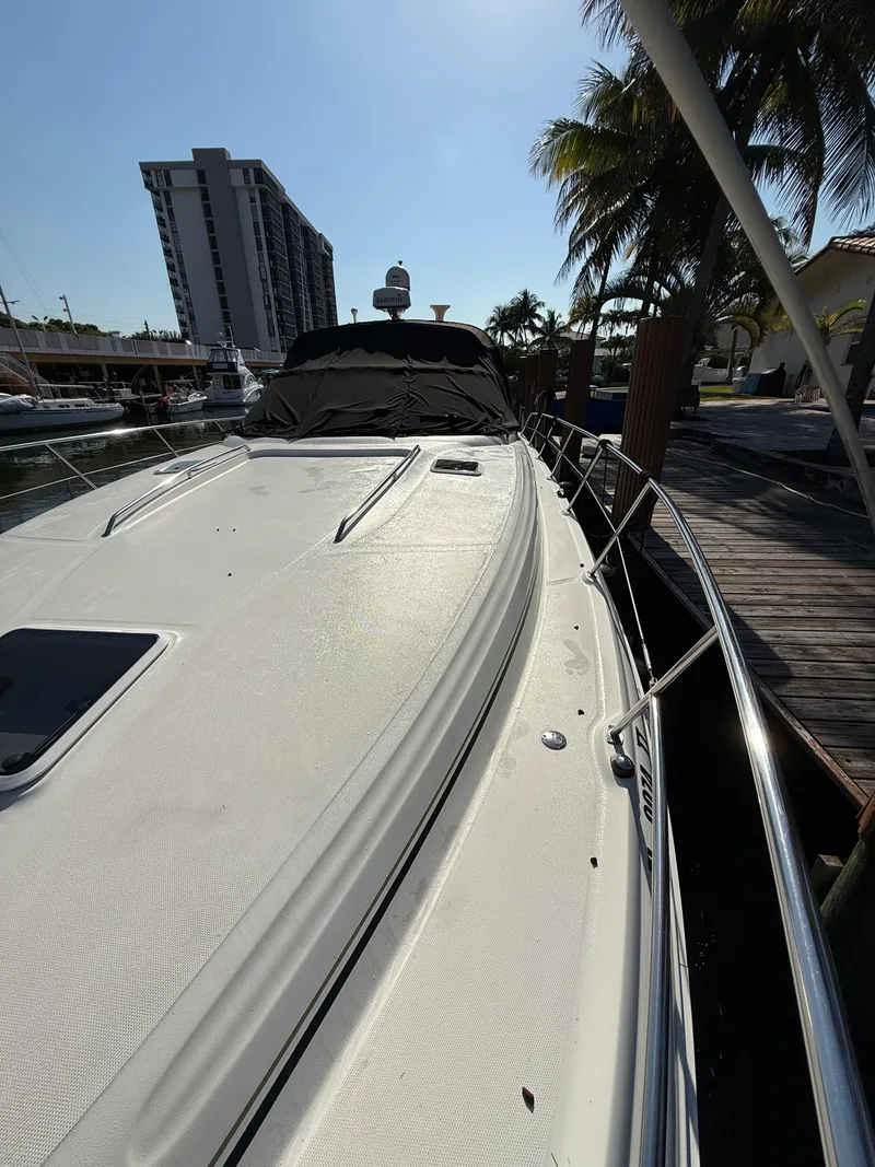 Slide: The Image of 2002 Sea Ray 410 Sundancer yacht docked near palm trees and buildings. - 5