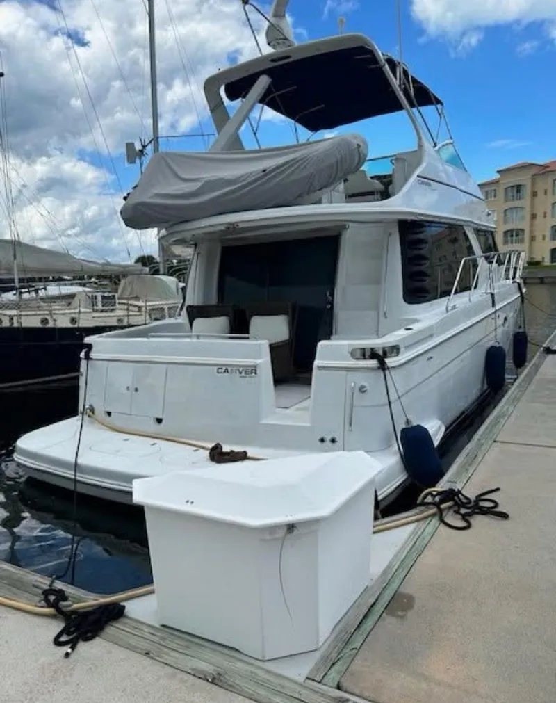 Slide: The Image of 2000 Carver 450 Voyager Pilothouse yacht docked at marina under cloudy sky. - 3
