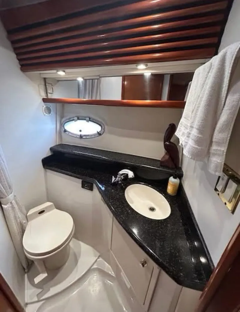 Slide: The Image of 2000 Carver 450 Voyager Pilothouse bathroom with black countertop and modern fixtures. - 7