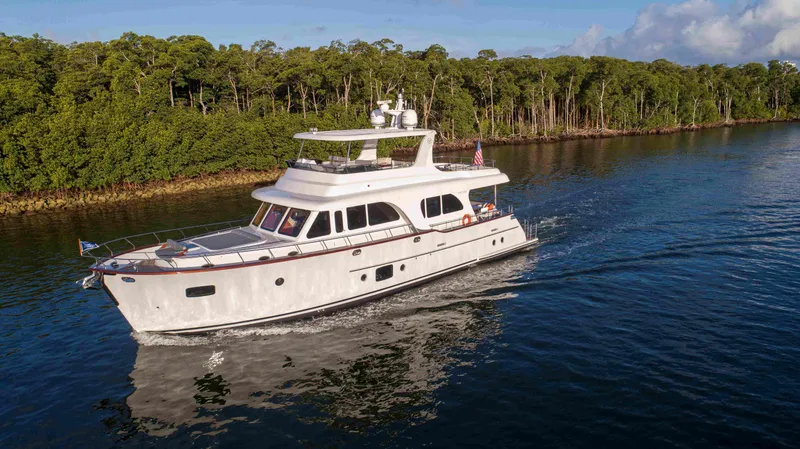 Slide: The Image of 2020 Vicem 67 Cruiser yacht navigating a serene waterway with lush greenery. - 2