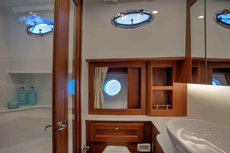 Slide: The Image of Luxurious bathroom interior of 2020 Vicem 67 Cruiser yacht with wooden accents and porthole windows. - 25