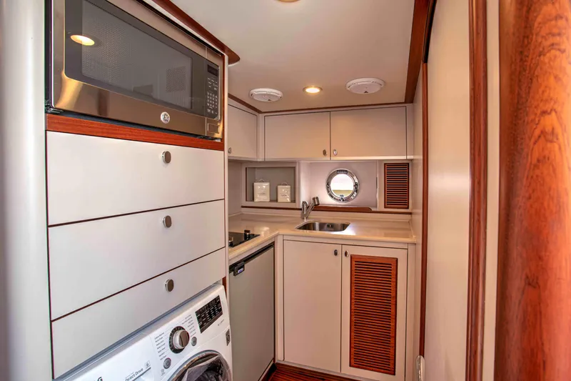 Slide: The Image of Compact galley kitchen in 2020 Vicem 67 Cruiser yacht with modern appliances and wood accents. - 34