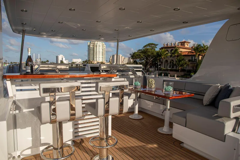 Slide: The Image of Luxurious 2020 Vicem 67 Cruiser yacht deck with seating, bar stools, and scenic waterfront view. - 7