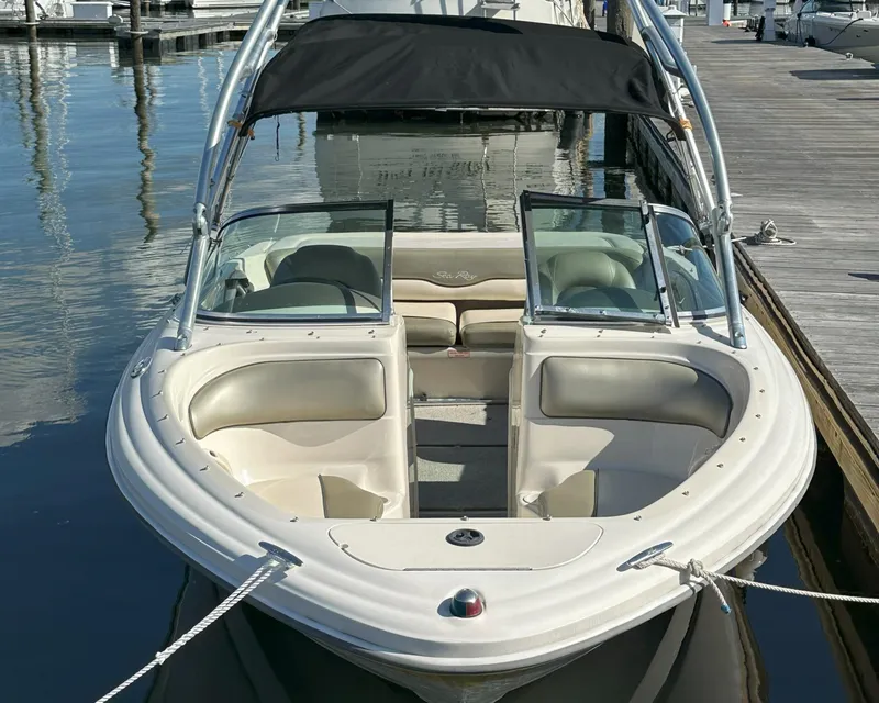 Slide: The Image of 2005 Sea Ray 185 Sport boat docked at marina, featuring open bow seating and black canopy. - 1