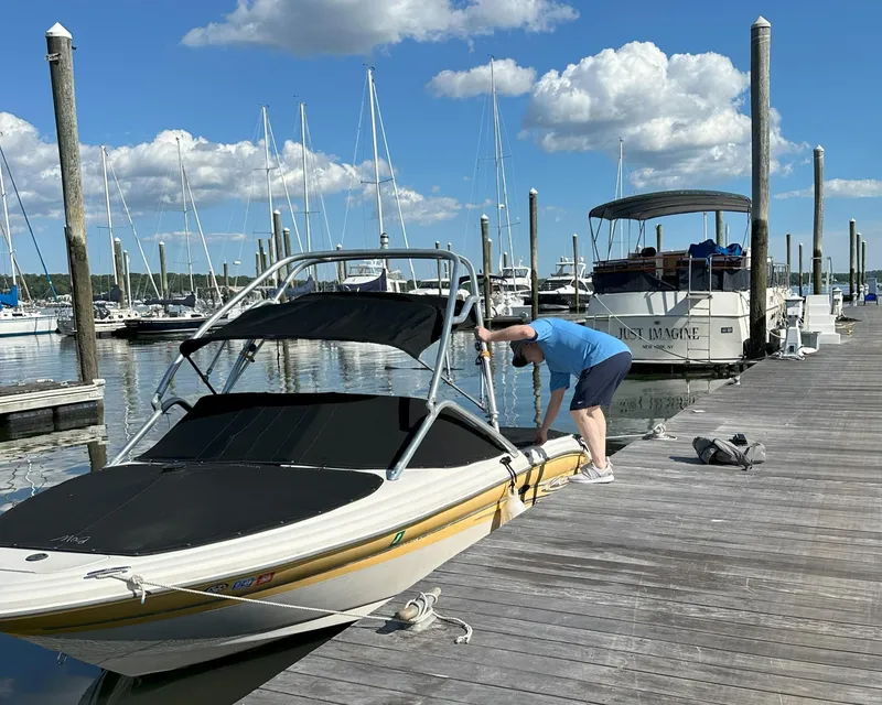 Slide: The Image of Man securing 2005 Sea Ray 185 Sport boat at marina dock. - 3