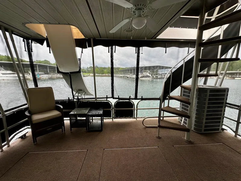 Slide: The Image of Houseboat interior with spiral staircase, ceiling fan, and lake view. Lakeview 16x68, 2004 model. - 13