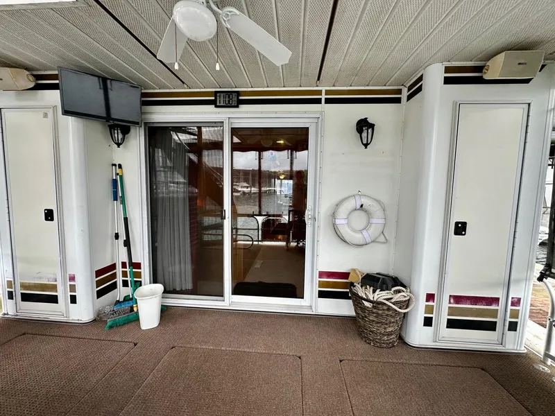 Slide: The Image of Houseboat deck with sliding glass door, ceiling fan, and life preserver. Lakeview 16x68, 2004 model. - 14