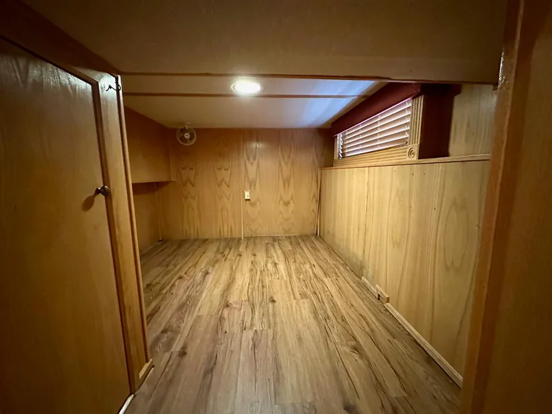 Slide: The Image of Wood-paneled room in 2004 Lakeview 16x68 model, featuring laminate flooring and a small window. - 8