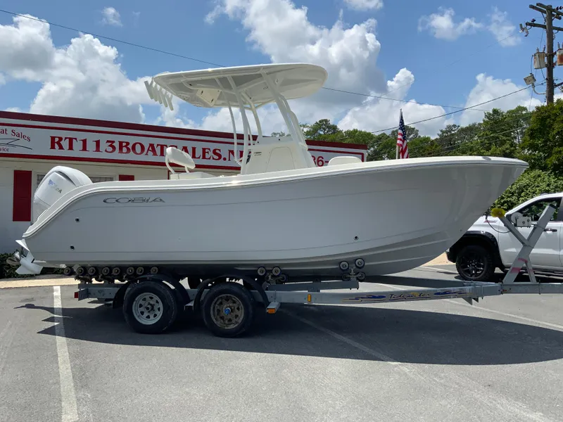 The Image of 2025 Cobia 220 Center Console boat on trailer at dealership. - 1