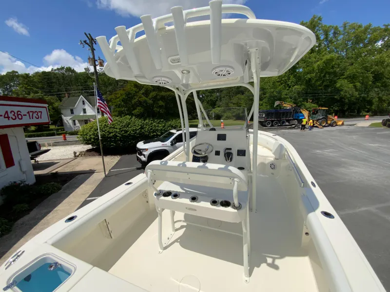 Slide: The Image of 2025 Cobia 220 Center Console boat with T-top, parked outdoors on a sunny day. - 10