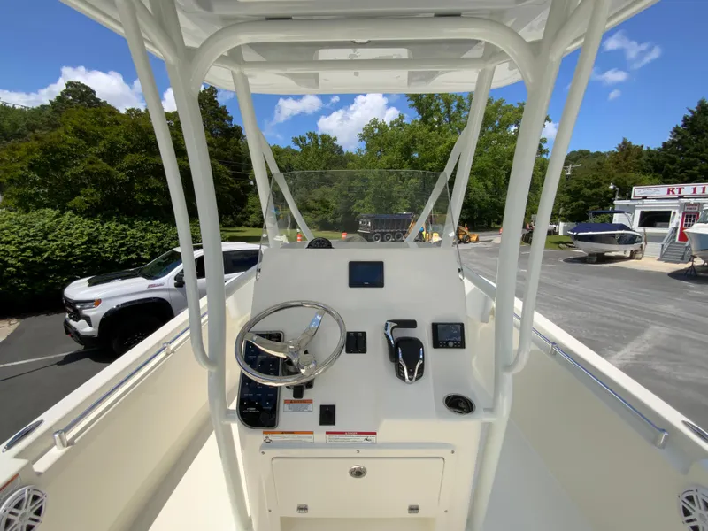 Slide: The Image of 2025 Cobia 220 Center Console boat dashboard with steering wheel and controls. - 11