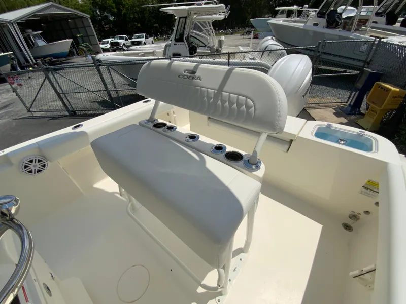 Slide: The Image of 2025 Cobia 220 Center Console boat with white seating and rod holders. - 12