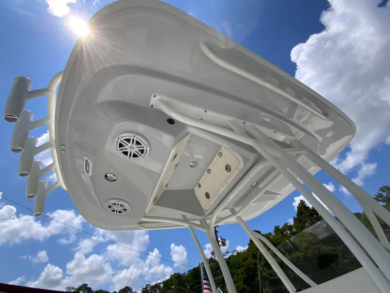 Slide: The Image of 2025 Cobia 220 Center Console boat under bright sun and blue sky. - 26