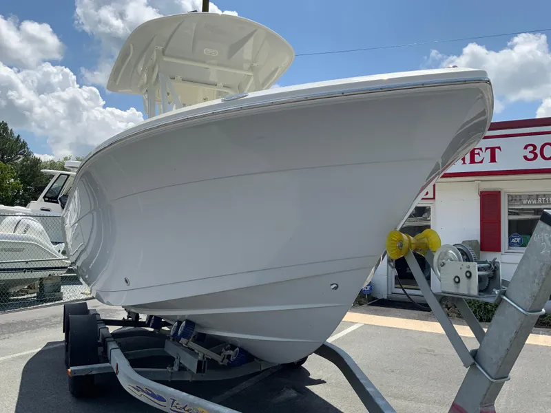 Slide: The Image of 2025 Cobia 220 Center Console boat on trailer, displayed outdoors under a blue sky. - 3