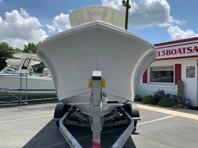 Slide: The Image of 2025 Cobia 220 Center Console boat on trailer at dealership, sunny day. - 4