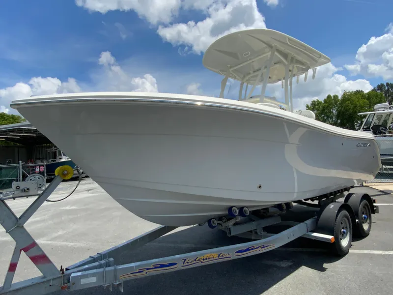 Slide: The Image of 2025 Cobia 220 Center Console boat on trailer under blue sky. - 5