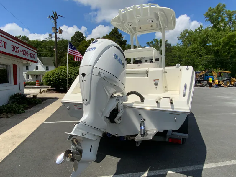 Slide: The Image of 2025 Cobia 220 Center Console boat with Yamaha outboard motor, parked outdoors. - 9