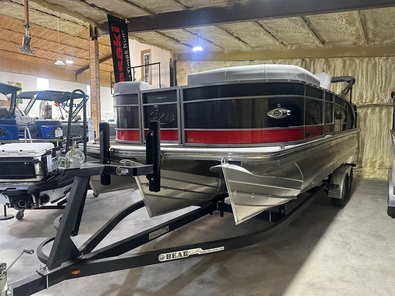 The Image of 2022 Manitou 23 Encore SL pontoon boat on trailer in indoor storage. - 0