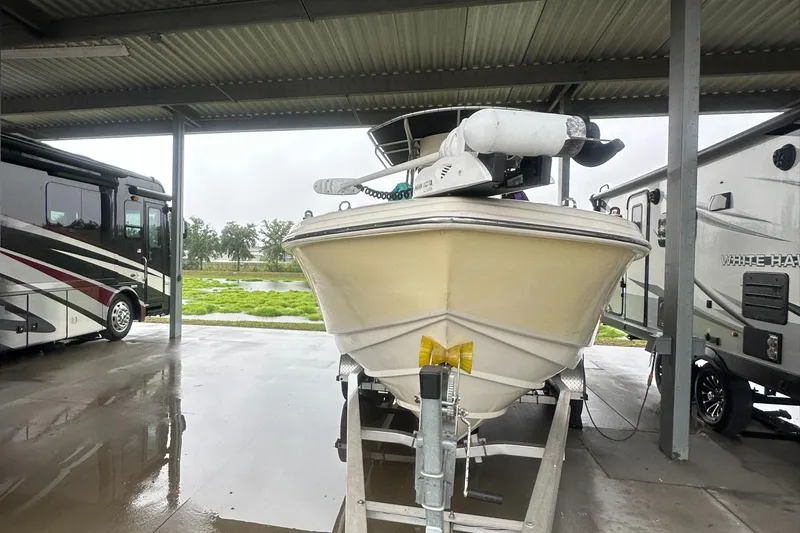 Slide: The Image of Scout 235 Sportfish boat on trailer, parked under shelter, with RVs nearby. - 11