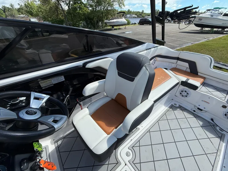 Slide: The Image of 2016 Yamaha AR240 boat interior with captain's seat and dashboard, docked near other boats. - 17