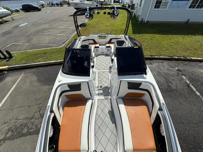 Slide: The Image of 2016 Yamaha Boats AR240 with orange seating, docked in a marina parking area. - 20