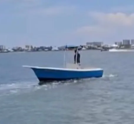 The Image of 1976 Shamrock Open Motorboat cruising on calm waters near a coastal cityscape. - 0