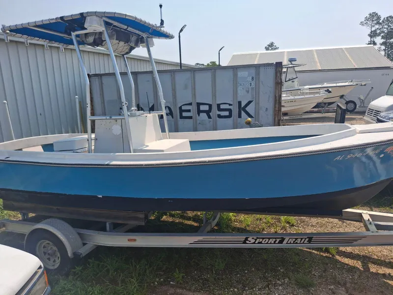 Slide: The Image of 1976 Shamrock Open Motorboat on trailer, blue and white, parked outdoors near shipping container. - 10
