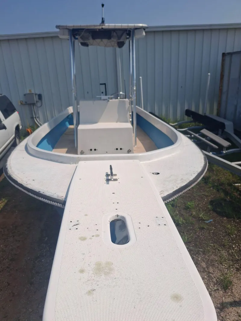 Slide: The Image of 1976 Shamrock Open Motorboat with white deck, docked outdoors near a metal building. - 11