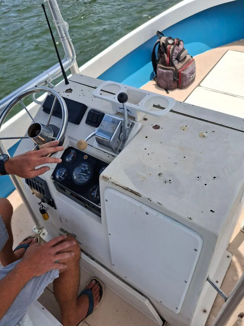 Slide: The Image of 1976 Shamrock Open Motorboat dashboard with steering wheel and controls, on a sunny day. - 3