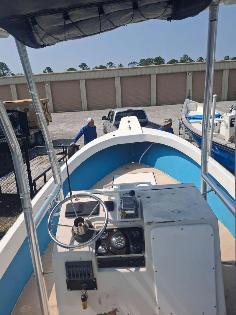 Slide: The Image of 1976 Shamrock Open Motorboat with blue interior, docked near storage units. - 7
