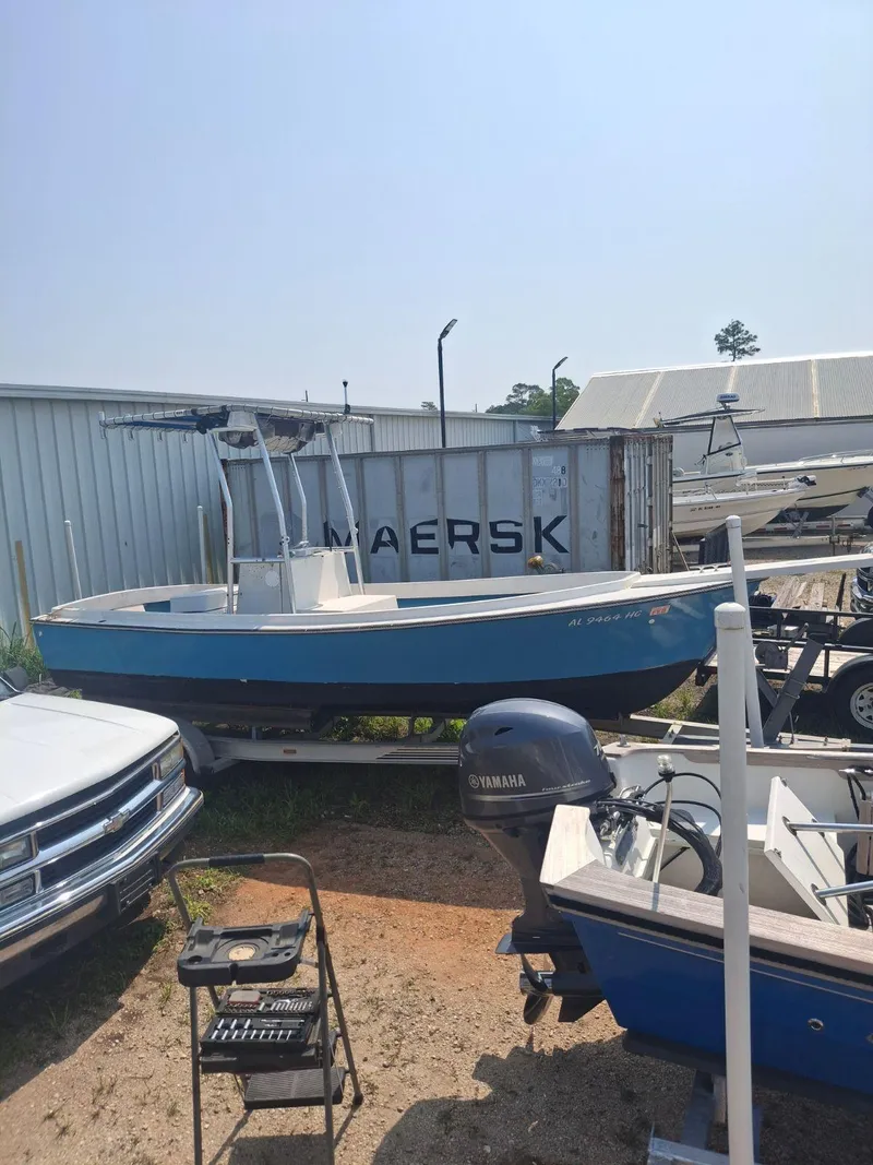 Slide: The Image of 1976 Shamrock Open Motorboat on trailer, parked near shipping container and vehicles. - 9