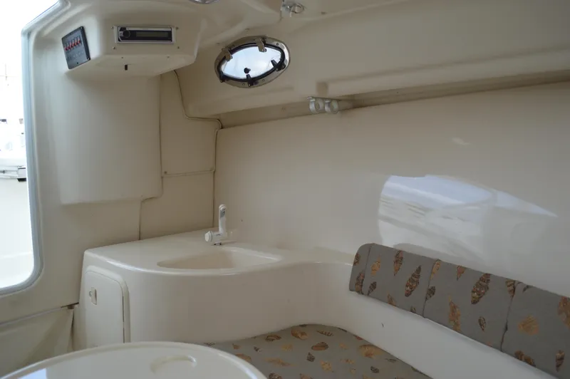 Slide: The Image of Interior of 2005 Wellcraft 252 Coastal boat, featuring a compact cabin with seating and sink. - 42