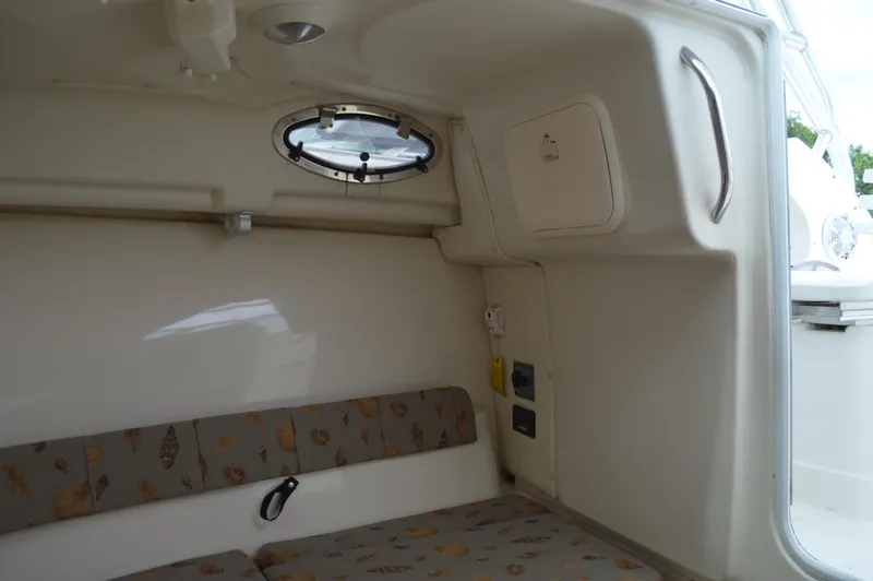 Slide: The Image of 2005 Wellcraft 252 Coastal cabin interior with seating and porthole. - 44