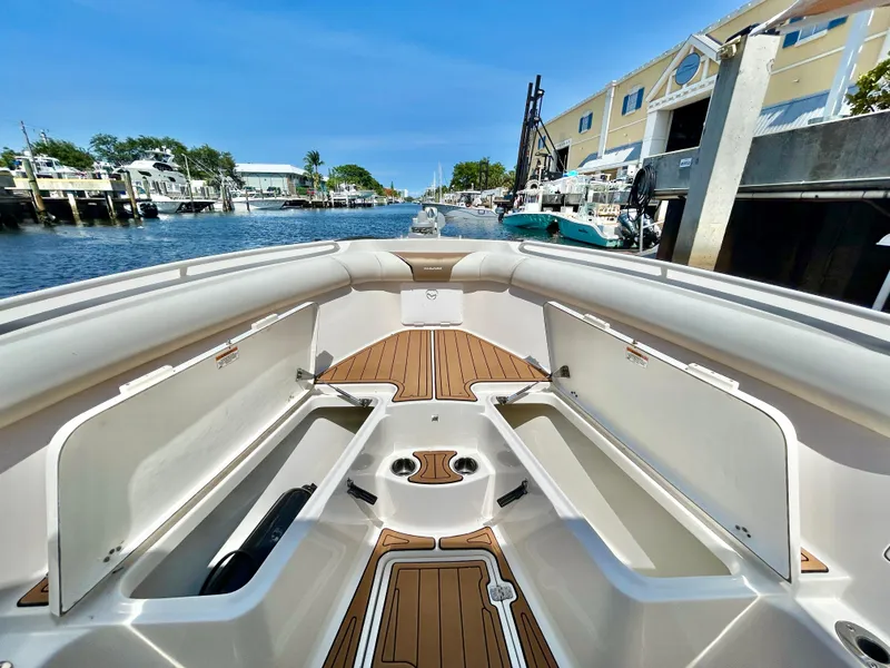 Slide: The Image of 2013 Sailfish 270 CC boat interior with open storage compartments, docked in a marina. - 13