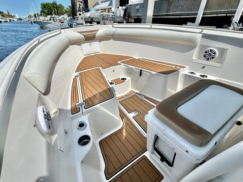 Slide: The Image of 2013 Sailfish 270 CC boat interior with cushioned seating and teak flooring. - 14