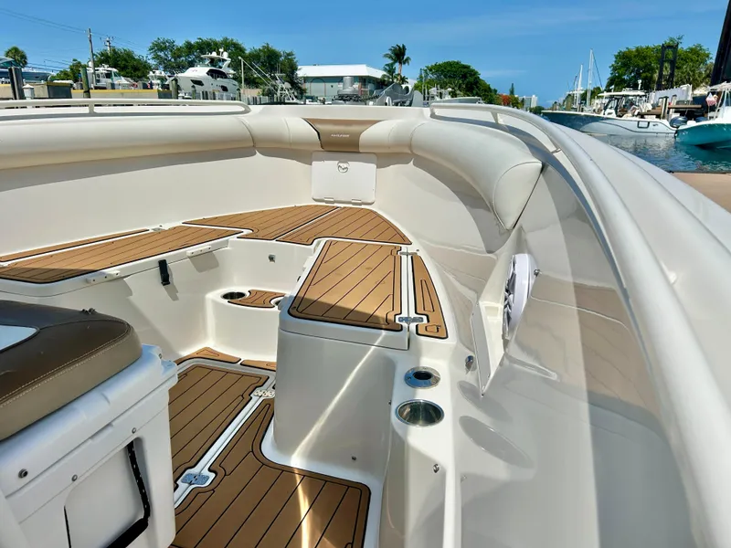 Slide: The Image of 2013 Sailfish 270 CC boat with teak deck, docked in a marina. - 15