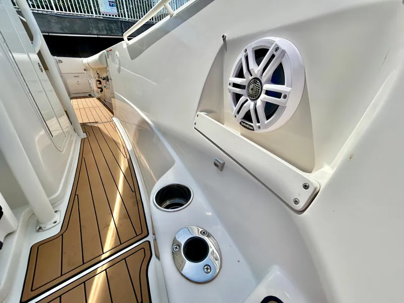 Slide: The Image of 2013 Sailfish 270 CC boat interior with teak flooring and speaker system. - 17