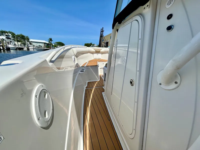 Slide: The Image of 2013 Sailfish 270 CC boat deck with sleek white design and wooden flooring. - 19