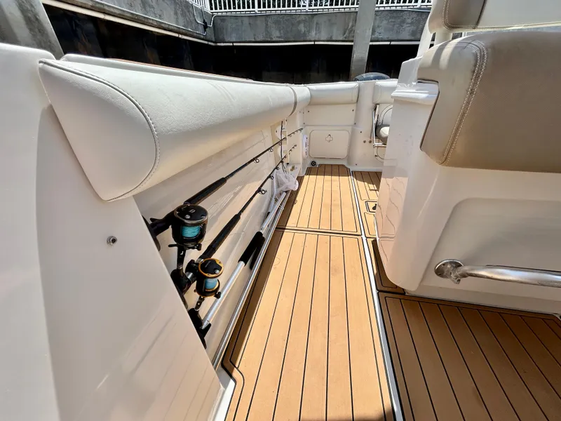 Slide: The Image of Interior view of 2013 Sailfish 270 CC boat, featuring rod holders and teak flooring. - 20