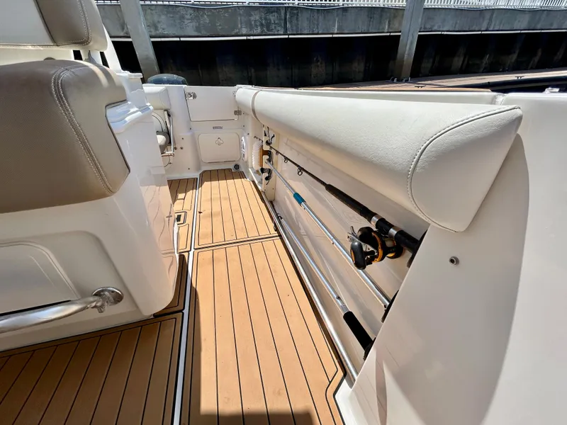 Slide: The Image of 2013 Sailfish 270 CC boat interior with rod holders and cushioned seating. - 21