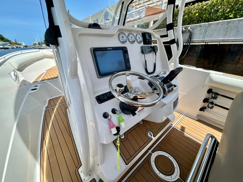 Slide: The Image of 2013 Sailfish 270 CC boat cockpit with steering wheel, navigation system, and control panel. - 25
