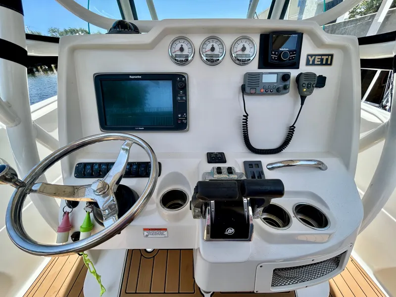 Slide: The Image of 2013 Sailfish 270 CC boat dashboard with steering wheel, gauges, and navigation equipment. - 29