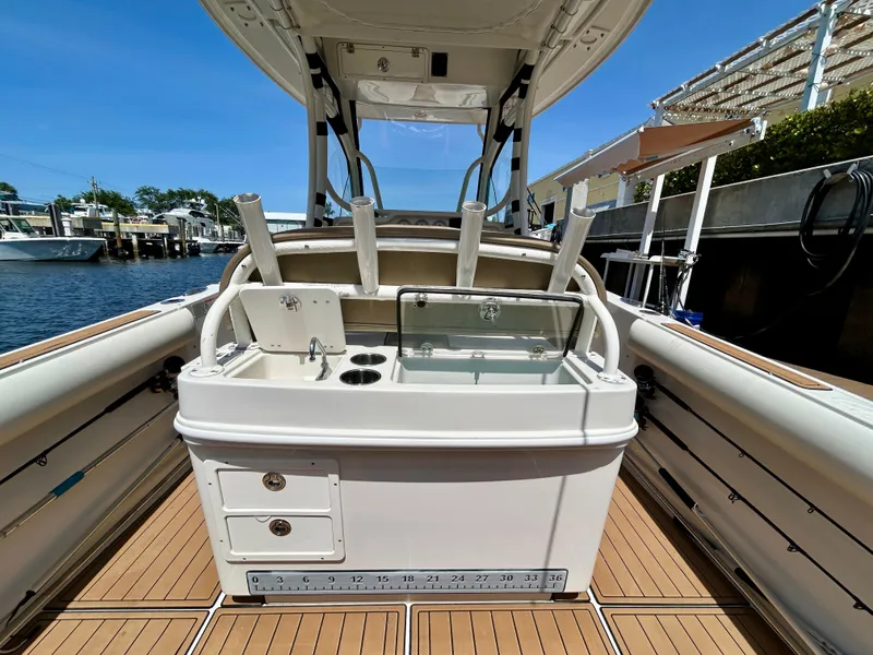 Slide: The Image of 2013 Sailfish 270 CC boat interior with fishing rod holders and storage compartments. - 34