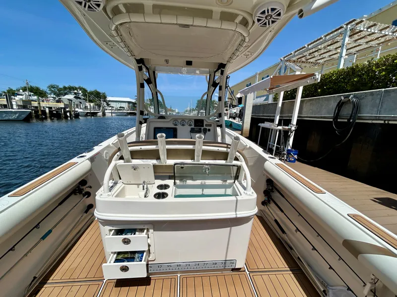 Slide: The Image of 2013 Sailfish 270 CC boat interior with fishing station and storage, docked by the water. - 35