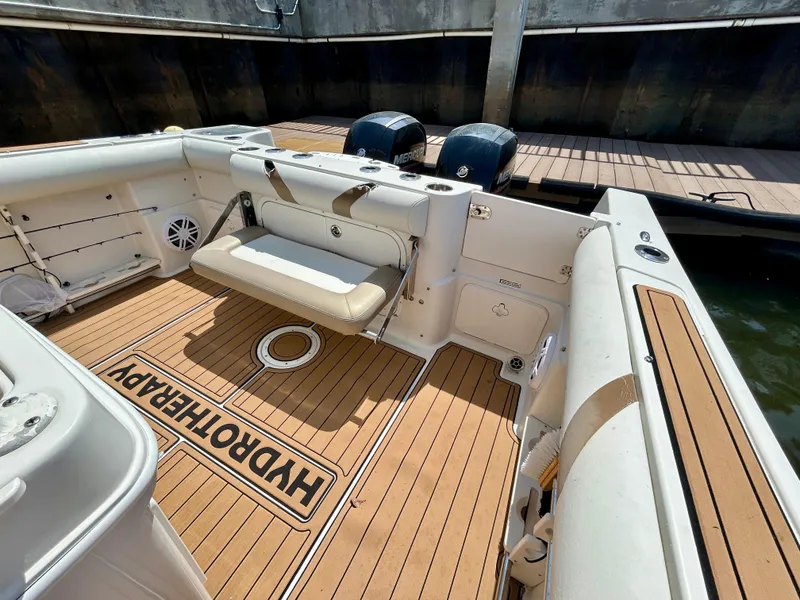 Slide: The Image of 2013 Sailfish 270 CC boat interior with teak flooring and dual outboard motors. - 41
