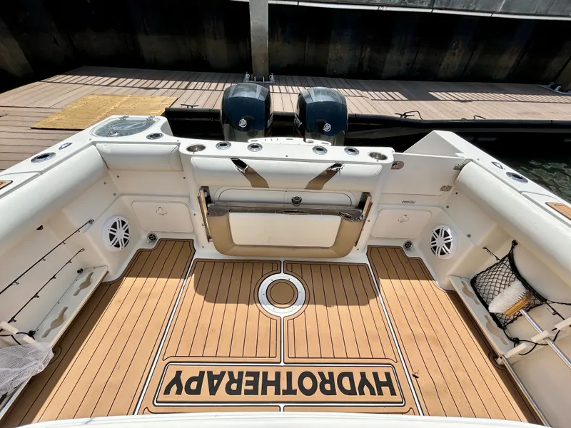 Slide: The Image of 2013 Sailfish 270 CC boat deck with twin engines and teak flooring. - 42