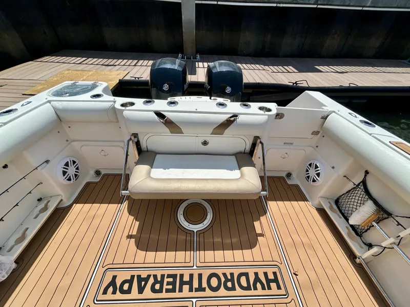 Slide: The Image of 2013 Sailfish 270 CC boat interior with seating and twin engines at dock. - 43