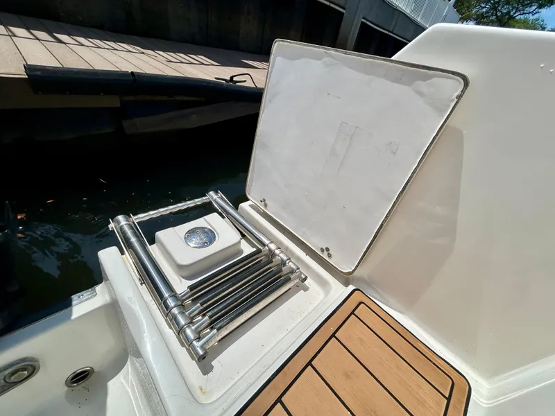 Slide: The Image of 2013 Sailfish 270 CC boat ladder and deck detail by the water. - 47