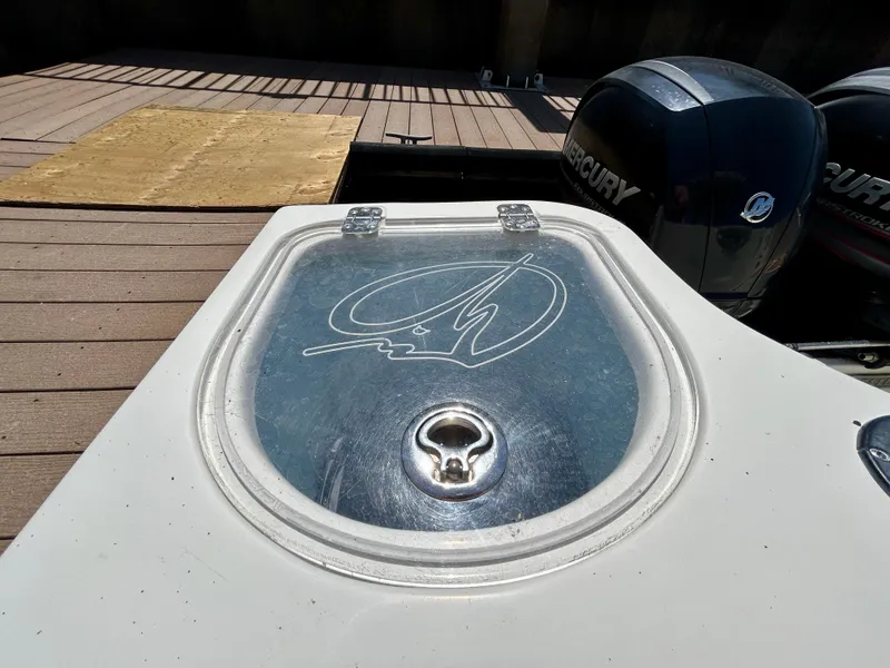 Slide: The Image of 2013 Sailfish 270 CC boat with Mercury engines, docked, featuring a closed hatch. - 48