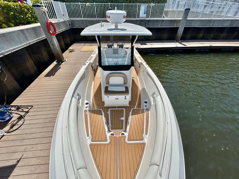 Slide: The Image of 2013 Sailfish 270 CC boat docked, featuring spacious deck and modern design. - 8